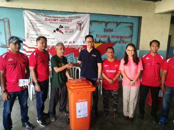 ADUN Bandar Baru Klang, Datuk Teng Chang Kim (empat,kiri) menyerahkan tong sampah untuk kegunaan penduduk pada Program Gotong-royong Basmi Aedes bersama Komuniti di Pangsapuri Dahlia di sini tadi.