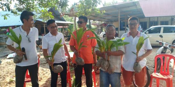 Norhizam (dua, kiri) menyampaikan sumbangan 400 anak pokok kelapa matak di Kampung Ayer Salak, Bukit Rambai di sini.