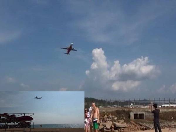 Pelancong bergambar berlatar belakang pesawat sedang berlepas di pantai berhampiran sekitar lapangan terbang di Thailand. - Mirror