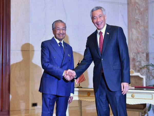 Perdana Menteri Tun Dr Mahathir Mohamad (kiri) bersalaman dengan rakan sejawatannya dari Singapura Lee Hsien Loong ketika perjumpaan bagi mengadakan perbincangan di bawah rangka kerja Pemukiman Pemimpin Malaysia-Singapura Kesembilan di Bangunan Perdana Putra hari ini.- Foto Bernama 