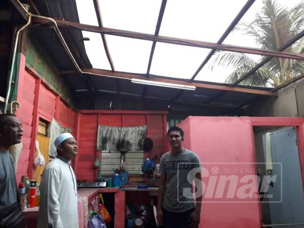 Ahmad Saqif (dua, kiri) meninjau keadaan bumbung rumah salah seorang mangsa di Kampung Sungai Baru, Selinsing yang terjejas teruk diterbangkan ribut lewat petang semalam.