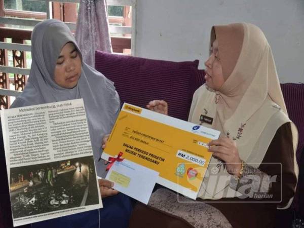 Farihah Che Husin (kanan) menyerahkan cek bayaran Faedah Pengurusan Mayat bernilai RM2,000 kepada ibu mangsa, Rohana Muda, di Bukit Payong, Marang, semalam. (Gambar kecil: Keratan akhbar Sinar Harian siaran 5 April lalu)