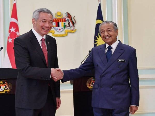 Tun Dr Mahathir Mohamad (kanan) bersalaman dengan rakan sejawatannya dari Singapura Lee Hsien Loong selepas sidang media sempena Pemukiman Pemimpin Malaysia-Singapura Kesembilan di Bangunan Perdana Putra hari ini. - Foto Bernama