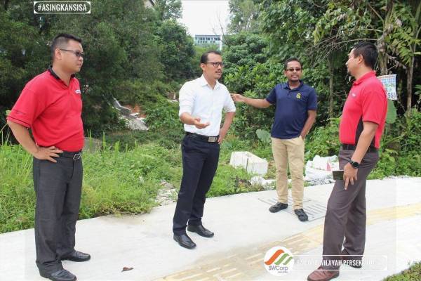 Mohd Zahir (dua, kiri) membincangkan isu pencemaran bau di longkang dan tapak pembuangan sampah haram yang berlaku di Jalan Mas 1, Kuala Lumpur hari ini. - FOTO: SWCorp