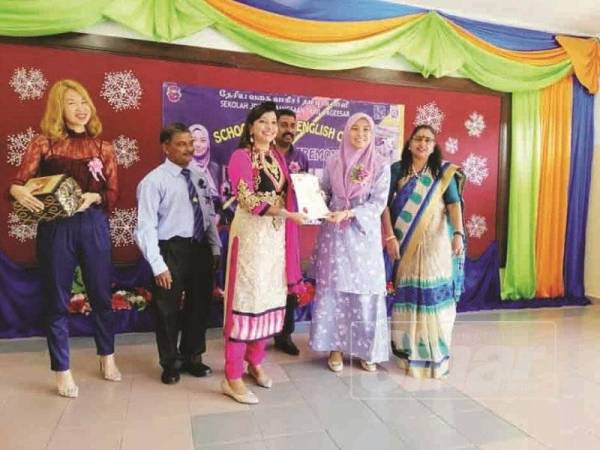 Juwairiya (kanan) menyampaikan sijil kepada guru pada Majlis Penutupan Projek Perintis School Heroes di Sekolah Jenis Kebangsaan Tamil (SJKT) Vageesar Kuala Selangor.