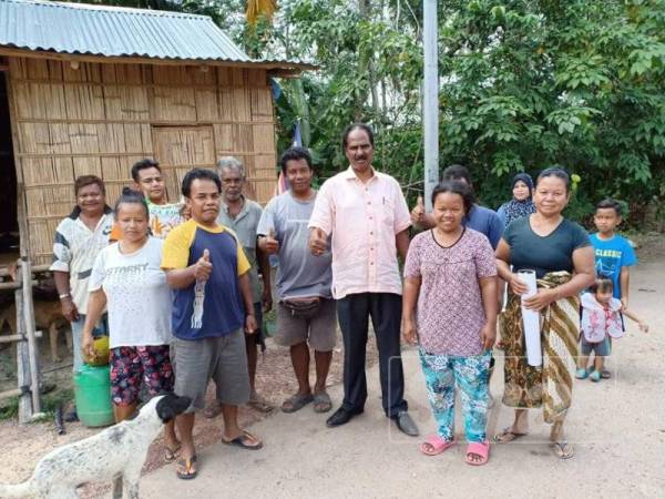 Manickam (tengah) bersama penduduk Kampung Orang Asli Lubuk Temenggalam, Jempol ketika melawat mereka. 