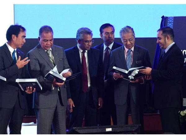 Mahathir melihat buku ‘Islamic Economic Principles & Analysis’ ketika Majlis Perasmian Forum Kewangan Islam Kuala Lumpur ke 15 2019 di sebuah hotel, hari ini. - Foto Bernama