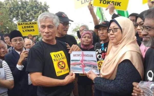 Pengerusi Save Malaysia Stop Lynas (SMSL), Tan Bun Teet (tengah) menyerahkan memorandum kepada Parlimen Kuantan, Fuziah Salleh di pekarangan Parlimen, Kuala Lumpur, hari ini.