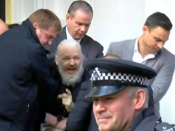 Julian Assange (tengah) ditahan di kedutaan Equador di London.
