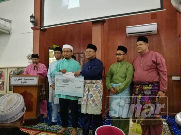 Amirudin menyampaikan sumbangan kepada masjid, surau dan madrasah di Masjid At-Taqwa, hari ini.