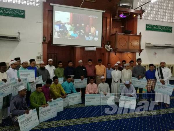 Amirudin bergambar kenangan bersama penerima sumbangan masjid, surau dan madrasah di Masjid At-Taqwa di sini, hari ini.