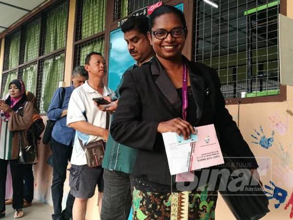 Malar mengotakan janji menjadi orang pertama sampai di pusat mengundi di SRJK (C) Rantau, hari ini.- Foto Sinar Harian