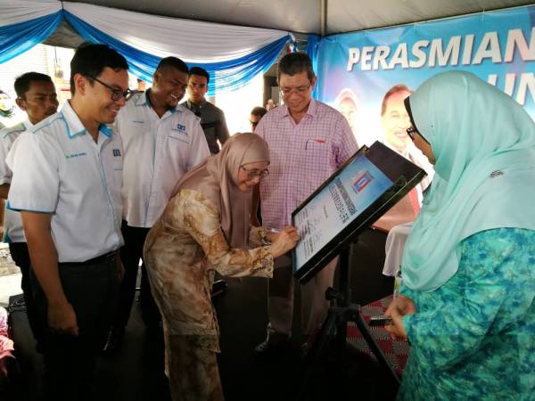 Dr Wan Azizah menurunkan tandatangan pada plak disediakan sebagai simbolik perasmian Pusat Komuniti Dun Beserah sambil disaksikan Chean Chung (kiri), Saifuddin dan Fuziah, di sini, hari ini.