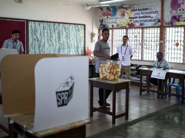 Pengerusi Suruhanjaya Pilihan Raya (SPR) Azhar Azizan Harun (tengah) meninjau proses mengundi bagi PRK DUN Rantau di Pusat Mengundi Sekolah Kebangsaan Nyatoh hari ini. -Foto Bernama