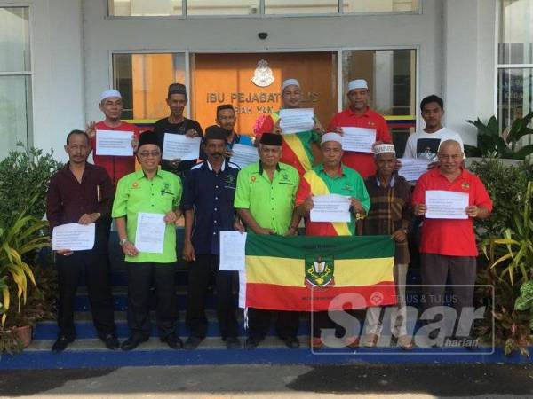 Abdul Aziz (dua dari kiri) bersama ahli Pekida Yan memegang salinan laporan polis di hadapan IPD Yan, hari ini.