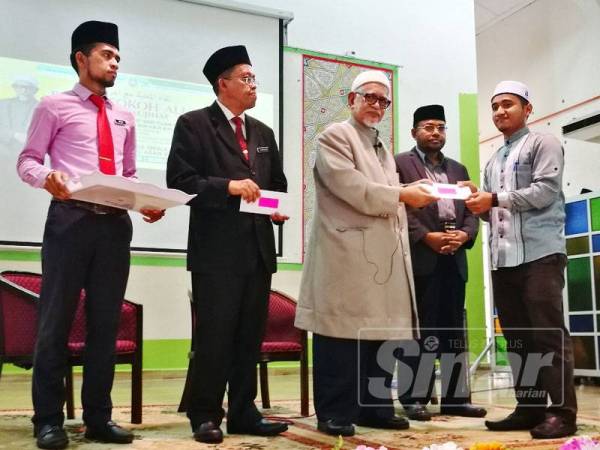 Abdul Hadi (tiga, kanan) menyampaikan sumbangan kepada pelajar SMAASZA sempena program Bicara Tokoh Alumni di sekolah itu, hari ini.