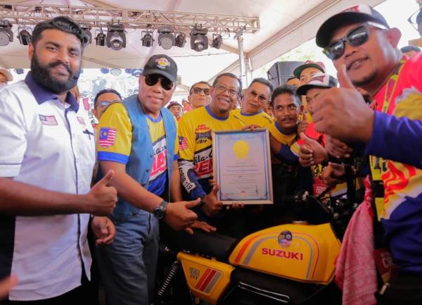 Abdul Rashid (dua dari kiri) dan Mohamad Zain (tiga dari kiri) ketika pengiktirafan himpunan 343 motosikal scrambler dalam Malaysia Book of Records di Morib hari ini.