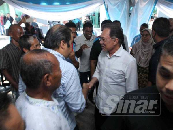 Anwar bersalaman dengan ahli PKR di pekarangan Pejabat Parlimen Kuantan hari ini.