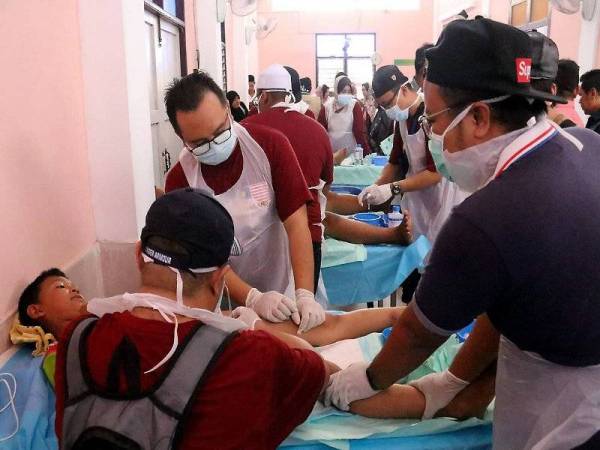 Sekumpulan doktor dari Malaysia menabur khidmat bakti dengan mengkhatankan 100 kanak-kanak secara percuma di Pattani, selatan Thailand. - Foto Bernama
