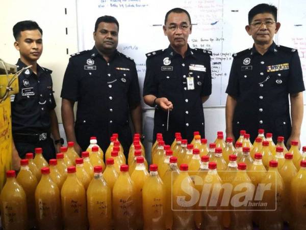 Nor Azmi (dua dari kanan) menunjukkan air ketum dan tong ikan yang dirampas pada sidang media di IPD Sabak Bernam, di sini.