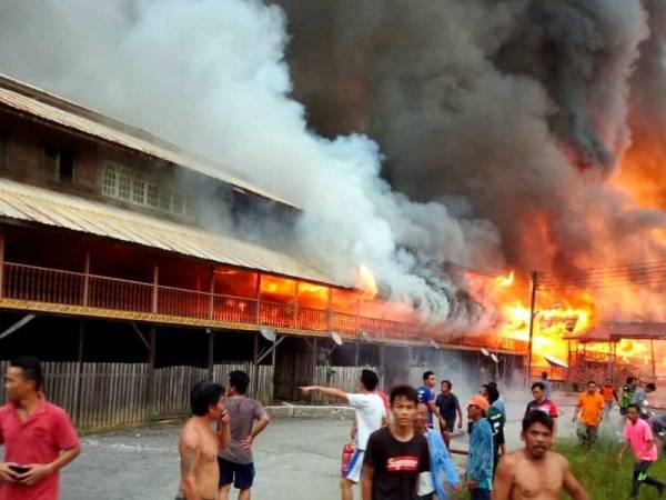 Sebahagian penduduk Uma Bawang Sungai Koyan Sungai Asap di Belaga hanya mampu melihat sahaja rumah panjang mereka dijilat api dalam kebakaran pada kira-kira 6 petang, - Foto Bernama