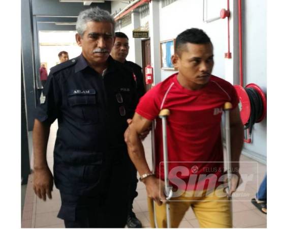 Khairul Amri diiringi polis di mahkamah hari ini.