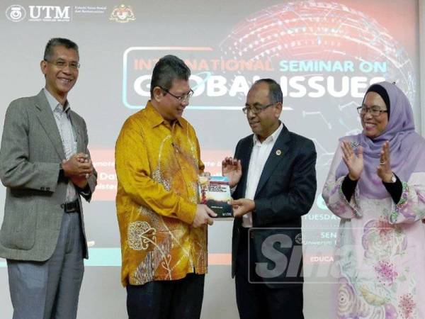 Saifuddin (dua,kiri) menerima cenderamata dari Wahid (tiga,kiri) selepas menyempurnakan Seminar Antarabangsa Mengenai Isu Global di UTM Skudai, di sini, hari ini.