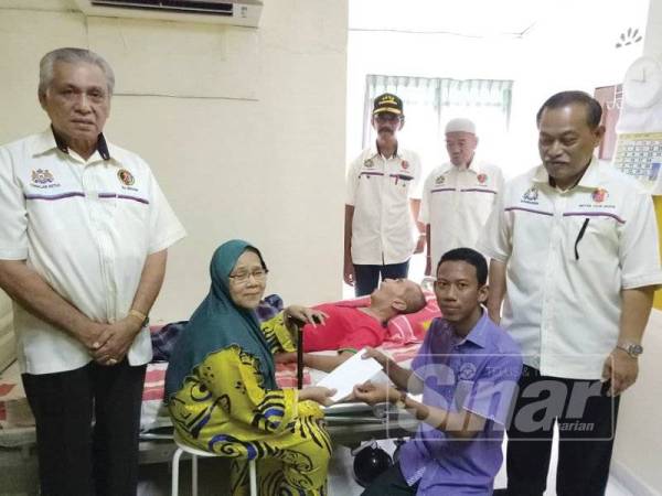 Maimunah menerima sumbangan kurniaan TMJ yang disampaikan oleh wakil Pejabat Daerah Muar, Mohamad Fahmi Zakaria sambil diperhatikan Ketua Cawangan PVATM Muar, Shamsuddin Rais (kanan) di Kampung Naib Piee, Bukit Pasir, Muar, semalam. 