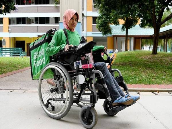 Sumaiyah nekad bekerja meskipun berkerusi roda. - Foto Berita Harian Singapura