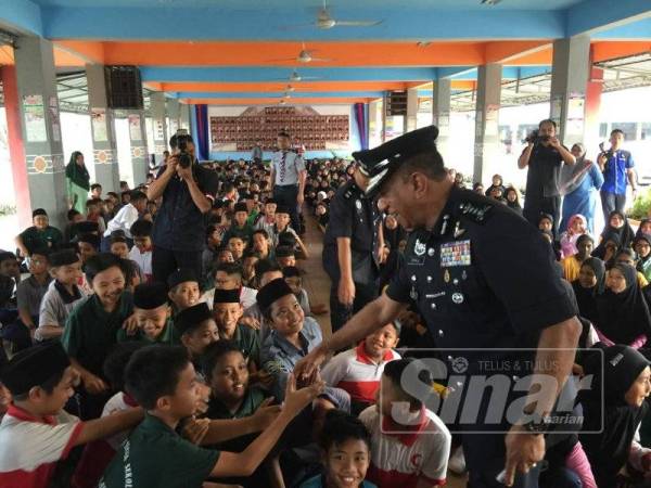 Mohd Khalil bersalaman dengan pelajar SK Polis Kem di Kulai, hari ini.