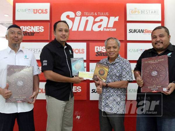 Khairul Annuar (dua dari kiri) menyerahkan cek kepada Muhammad Nasir (dua dari kanan) bersama dengan Shahnaz Khan (kanan) dan Hassan (kiri) sambil memegang naskah Al-Quran yang akan disumbangkan kepada 50 masjid di Narahiwat, Thailand di Ibu Pejabat Kumpulan Media Karangkraf, Shah Alam semalam. - Foto: ASRIL ASWANDI SHUKOR