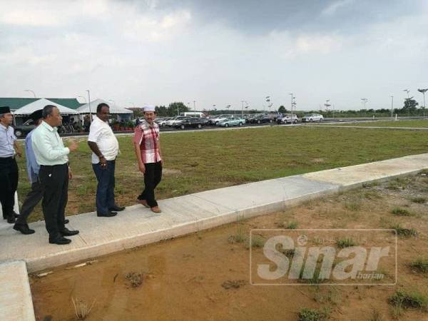 Mohd Yasid bersama Ahmad Zawawi meninjau tanah perkuburan baharu, semalam.