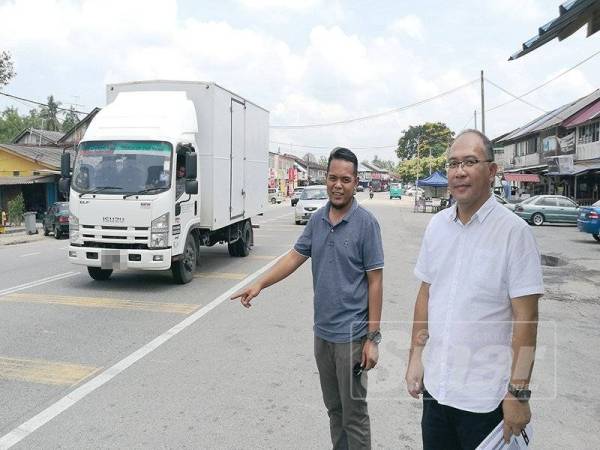 Abdul Ajib (kiri) dan Zulkifly (kanan) menunjukkan lokasi tapak bazar Ramadan Pekan Ayer Baloi yang terletak di bahu jalan utama Pontian-Batu Pahat. 