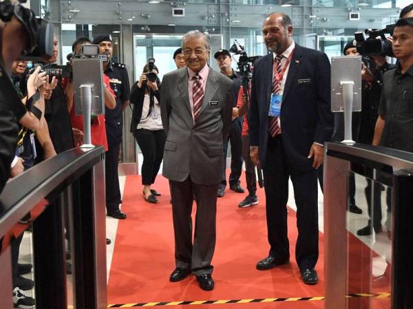 Perdana Menteri Tun Dr Mahathir Mohamad (tengah) melalui pemeriksaan ‘Intelligent Facial Biometric’ semasa hadir pada pelancaran '5G Malaysia Progressing Humanity' hari ini. - Foto Bernama