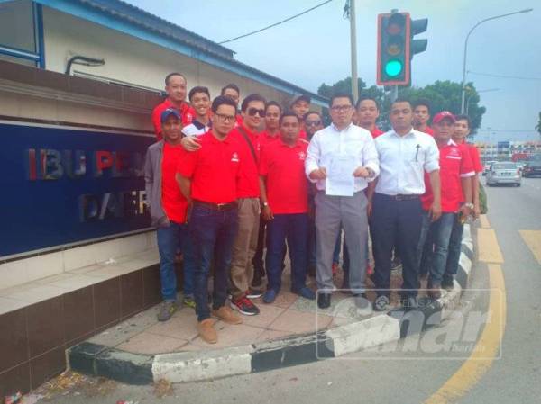 Azrul Hakkim menunjukkan laporan polis yang dibuat bersama-sama ahli Armada Bersatu Perak di hadapan IPD Ipoh, hari ini.