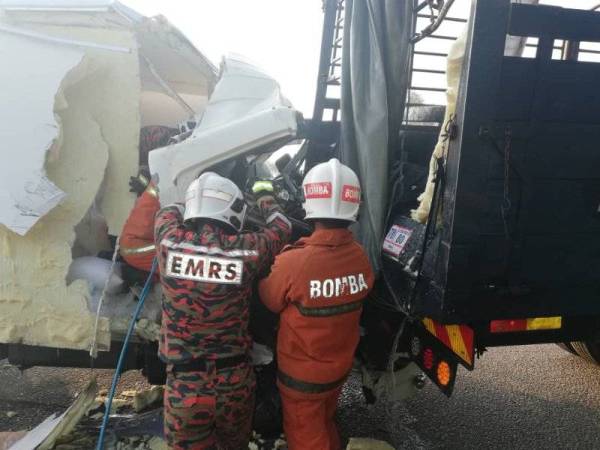 Anggota bomba membantu mengeluarkan mangsa yang tersepit. - Gambar Ihsan Bomba