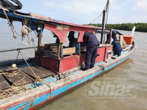 Anggota Maritim melakukan pemeriksaan terhadap bot nelayan yang ditinggalkan selepas dua nelayan terjun ke laut melarikan diri, awal pagi tadi. Foto: Maritim