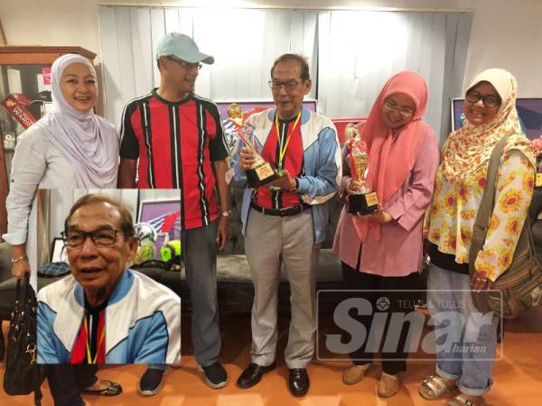 Abdul Rashid (tengah) melihat piala yang dipertandingkan dalam Kejohanan Futsal Piala Tan Sri Abdul Rashid di KB Futsal Arena, Padang Tembak hari ini.