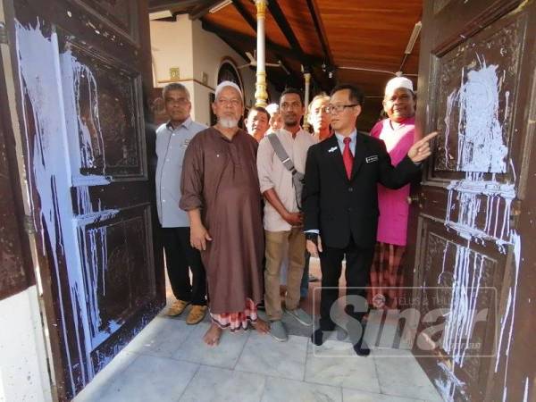 Chee Leong ketika melihat pintu Masjid Tengkera yang dicemari dengan simbahan cat bewarna ungu.