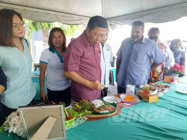 Kok Yew (tiga dari kiri) sempat merasa kerabu yang dipertandingkan sempena program Rapat Rakyat di Dewan Jitra, semalam.