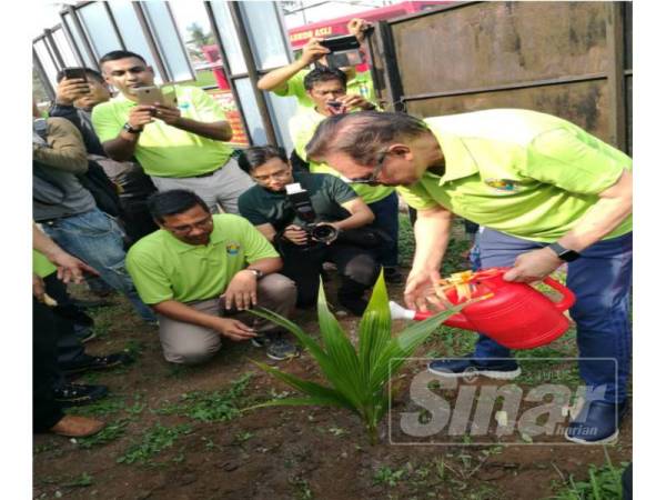 Anwar menyiram selepas menanam kelapa pandan sebagai simbolik perasmian Hari Bumi Sedunia peringkat Dun Bagan Pinang dan Hari Ladang Pejabat Pertanian Port Dickson di Balai Raya Bagan Pinang, hari ini.