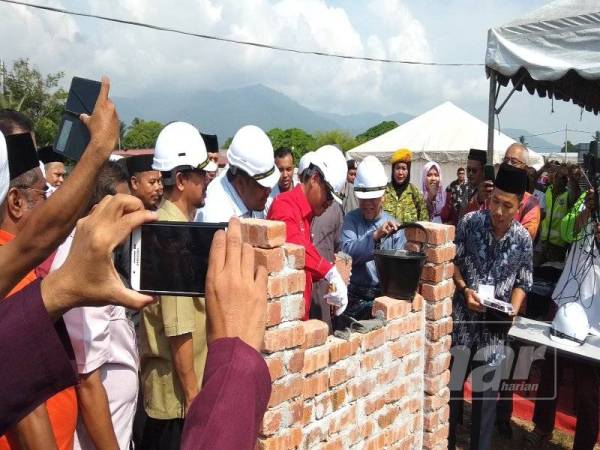 Ahmad Faizal meletakkan batu asas sebagai gimik perasmian majlis tersebut di tapak projek pengajian Islam, hari ini.