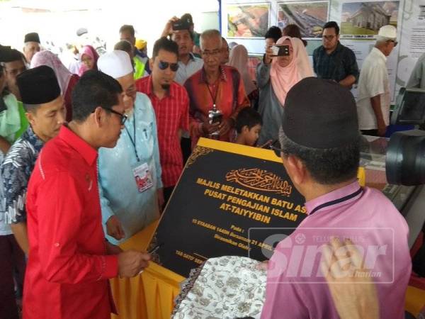 Ahmad Faizal menurunkan tandatangan pada plak perasmian selepas menyempurnakan gimik perasmian meletakkan batu asas Pusat pengajian tersebut, di sini, hari ini. 