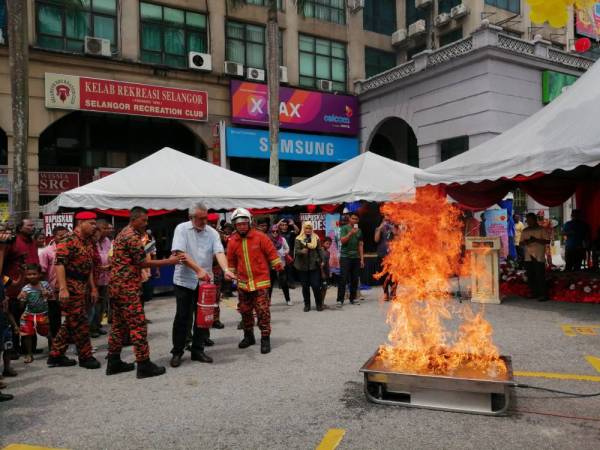 Khalid menunjukkan demonstrasi memadam kebakaran menggunakan alat pemadam api. 