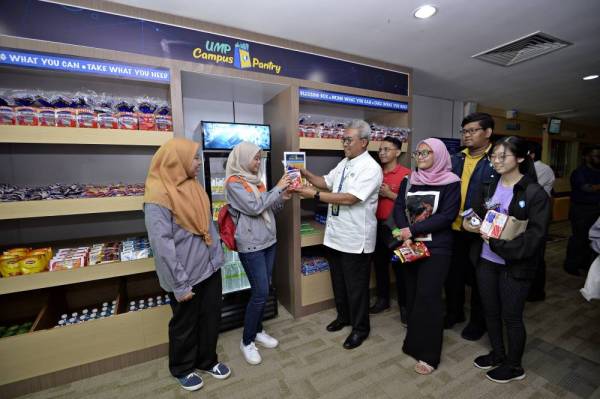 Dr Yuserrie mengagihkan makanan percuma kepada mahasiswa yang datang ke UMP Food Pantry pada hari pertama pembukaannya, semalam.