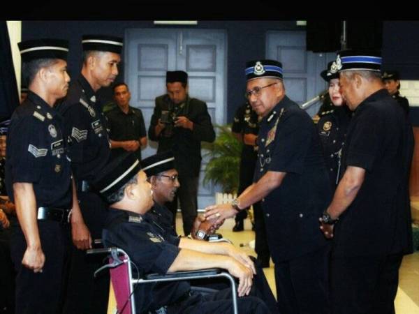 Mohamad Fuzi memakaikan pingat kepada pegawai dan anggota pada Istiadat Penganugerahan Pingat Jasa Pahlawan Negara di Markas Briged Tenggara Pusat Gerakan Am (PGA) Kem Bukit Galing, semalam.
