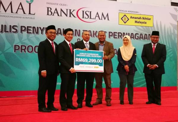 Ya’acob (tiga, kiri) menerima replika cek sumbangan Amal Musa’adah Bank Islam daripada Mohd Muazzam (dua, kiri).