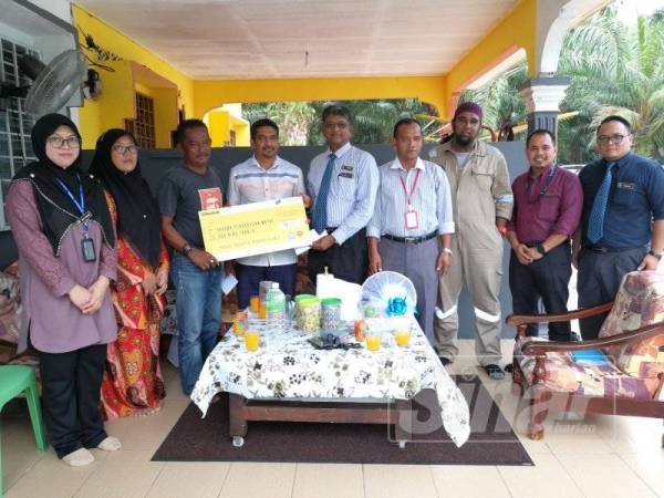 Mazlan (tiga dari kiri) sebak menerima replika cek sumbangan khairat kematian yang disampaikan ADUN Jeram, Mohd Shaid Rosli bersama Mohandas (lima dari kanan) ketika kunjungan di rumah waris di Jalan Ibrahim, Simpang 3 Jeram, hari ini.