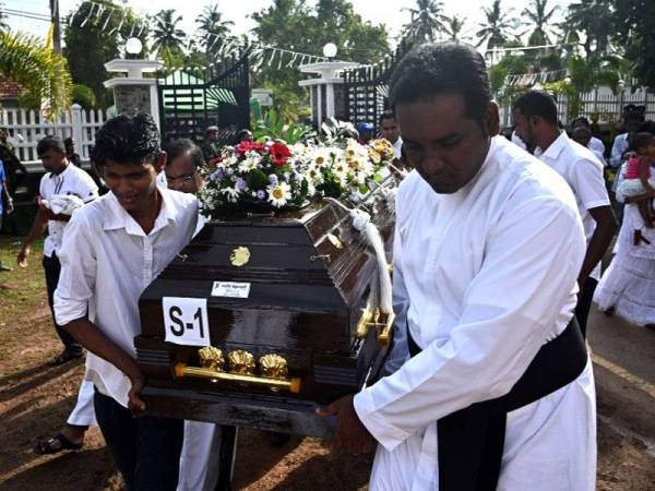 Paderi dan ahli keluarga mengusung mayat mangsa letupan bom susulan majlis pengebumian di Gereja St Sebastian.Sri Lanka digemparkan dengan lapan letupan bom yang menyasarkan beberapa gereja dan hotel terkemuka pada Ahad lalu yang meragut lebih 300 nyawa. - Foto AFP