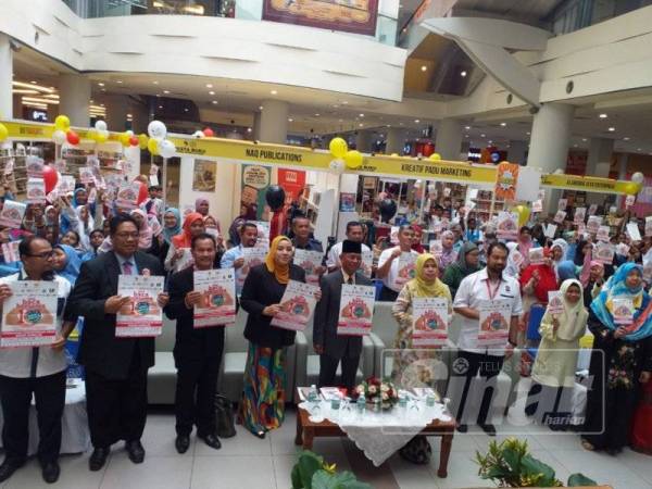 Hasan (lima kanan), Jamilah (enam kanan) menunjukkan poster kempen membaca pada majlis tersebut di Mydin Mall Seremban 2.